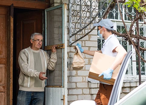 Home Delivered Meals for adults over 60 - image of food delivery at senior's home - Encompass Community Supports